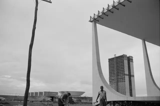 foto de dois trabalhadores durante a construção de Brasília, ao fundo está o Congresso Nacional